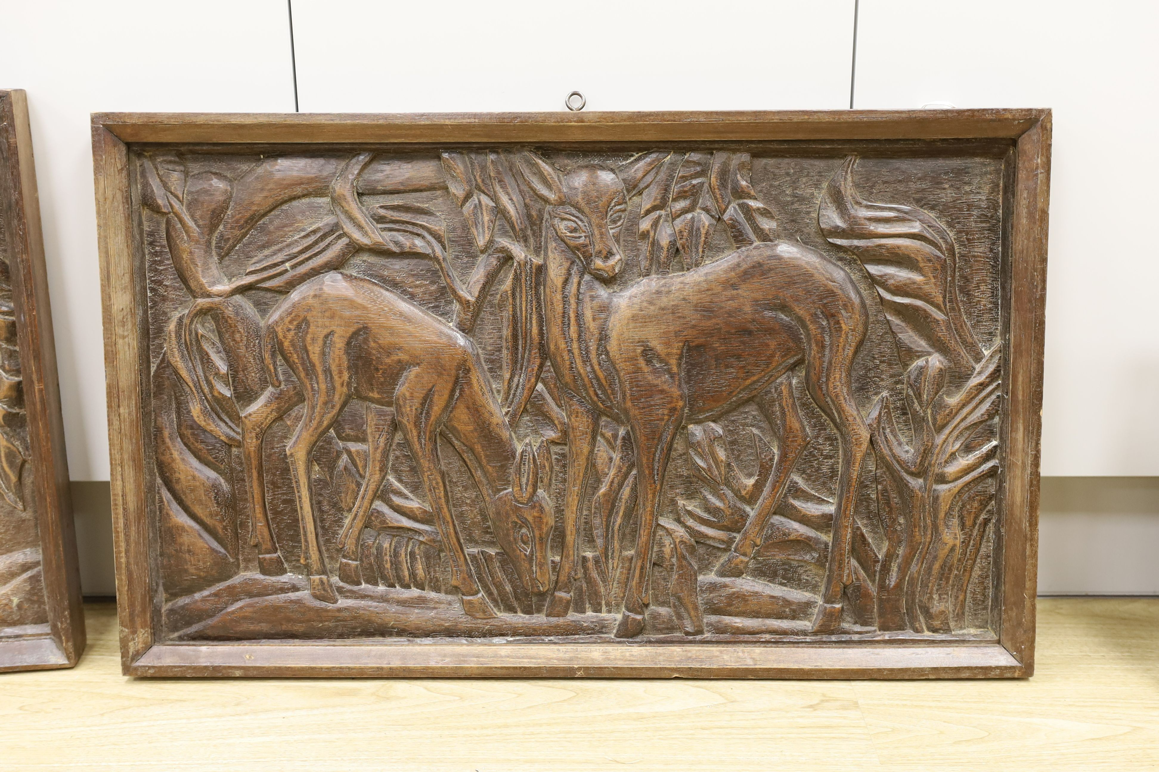 A pair of 1930's carved oak panels of deer grazing, 84 cms wide x 52 cms high.
